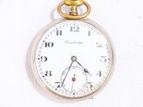 a close up of a pocket watch on a white surface