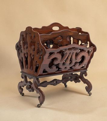 a wooden magazine rack with a carved design on it