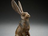 une statue en bronze représentant un lapin assis sur ses pattes arrière