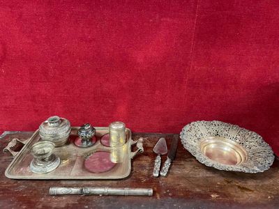 un plateau en argent sur lequel sont posés des objets en argent, posé sur une table en bois
