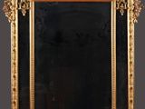 an ornate gold framed mirror on a wall with a black background