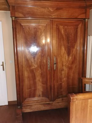 a wooden armoire in the corner of a room