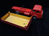 a red toy truck and a yellow box on a black background
