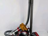 a black and red vacuum with a yellow ball on it
