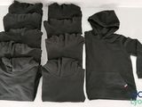 quatre paires de gants et un sweat à capuche posés sur une surface blanche