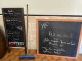 un tableau noir sur lequel sont écrites des notes, à côté d'un effaceur en bois