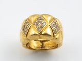 gros plan d'une bague en or avec des diamants sur fond blanc