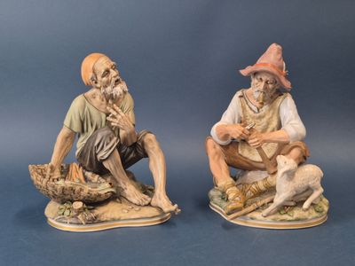 deux figurines d'un homme et d'une femme assis sur un rocher