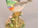 porcelain figurine of a hummingbird perched on a branch with flowers