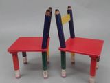 two chairs made out of pencils sitting on a table