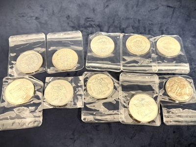 six gold coins in clear plastic bags sitting on a table