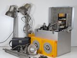 a silver box with a yellow box on top of it next to a pair of lamps and a pair of scissors