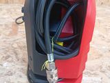 a close up of a red and black vacuum on a wooden surface