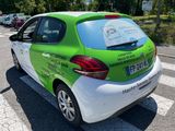 a green and white car parked on the side of the road