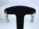 gros plan d'une paire de boucles d'oreilles sur un support noir