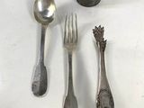 four spoons and a fork on a white table