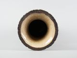 a brown vase sitting on a table with a white background