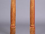paire de colonnes en bois sculpté avec des socles rouges sur fond gris