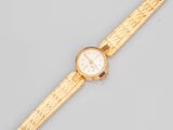 un gros plan d'une montre-bracelet en or avec un cadran blanc