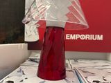 un vase rouge posé sur des cartons