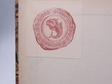 an old book with a stamp on it sitting on a table