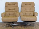 pair of mid - century swivel chairs with upholstered cushions