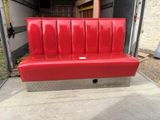 a red bench that is sitting in the back of a truck