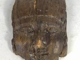 an old carved wooden head of a person with a smile on it ' s face