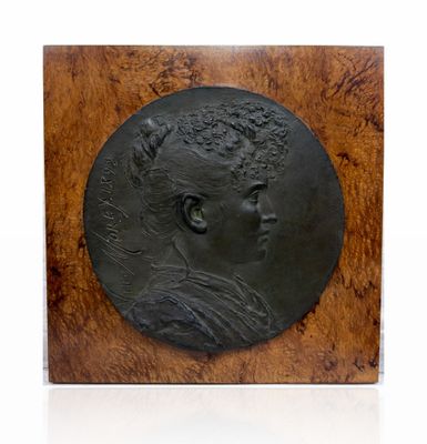 une plaque antique en bronze représentant une femme coiffée d'une couronne