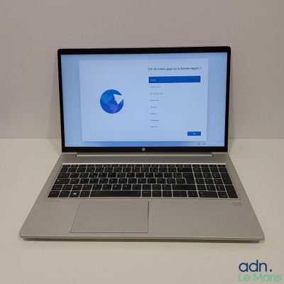 un ordinateur portable ouvert posé sur une table blanche