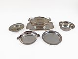 several pieces of silverware are arranged on a white surface