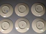 six white plates with different designs on them sitting on a table