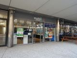 une photo d'une devanture de magasin avec un banc devant