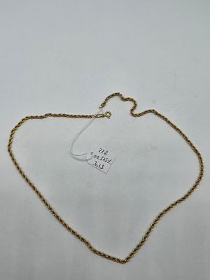 a gold chain with a tag attached to it on a white surface