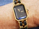 a woman wearing a gold and black watch on her wrist