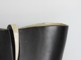 a close up of a black vase on a white surface