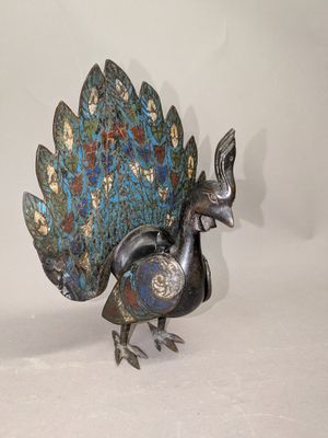 un oiseau en métal posé sur une surface blanche