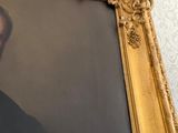 portrait of a man in a suit and tie in a gold frame