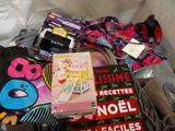 a pile of clothing and a book on a bed