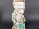 a figurine of a man with a book in his hand
