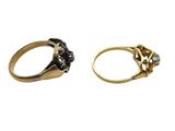 two gold rings with black diamonds and a white diamond