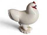 un petit oiseau blanc au bec rouge, posé sur une surface blanche