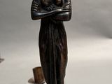 a statue of a woman with a crown on her head next to a candle