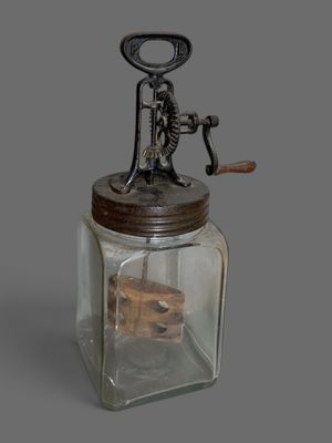 a glass jar with a wooden handle and a metal lid