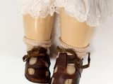 a close up of a doll ' s feet with shoes on