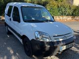 La camionnette blanche est garée sur le parking, à côté d'un arbre.