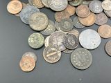 a pile of old coins on a black table
