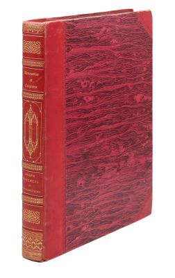 un vieux livre à la couverture rouge posé sur une surface blanche