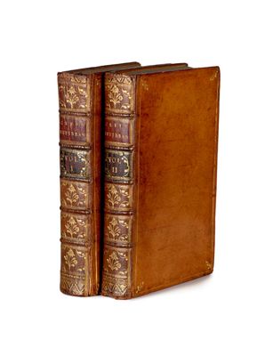 un vieux livre à la couverture en cuir posé sur une surface blanche