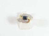 a close up of a ring with a blue sapphire and white diamonds